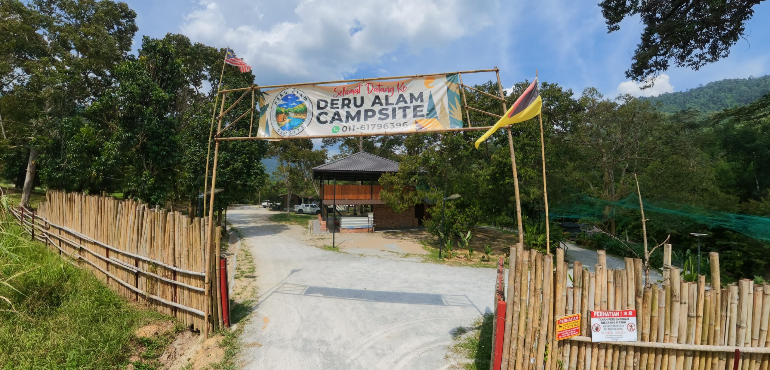 Bamboo entrance gate with the Deru Alam Campsite welcome banner